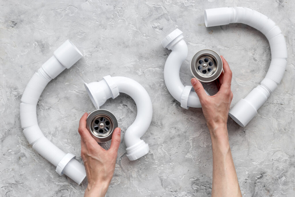 Clear clogged sink drains. Parts on grey stone background top view