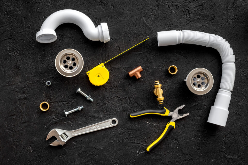 Plumber tools on black background top view